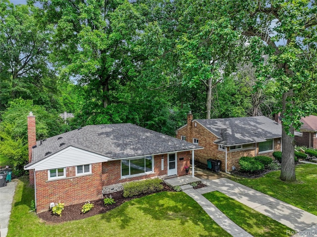 21710 Whitmore St, Oak Park, MI 48237 - view of front of property with a chimney, brick siding, driveway, and a front yard