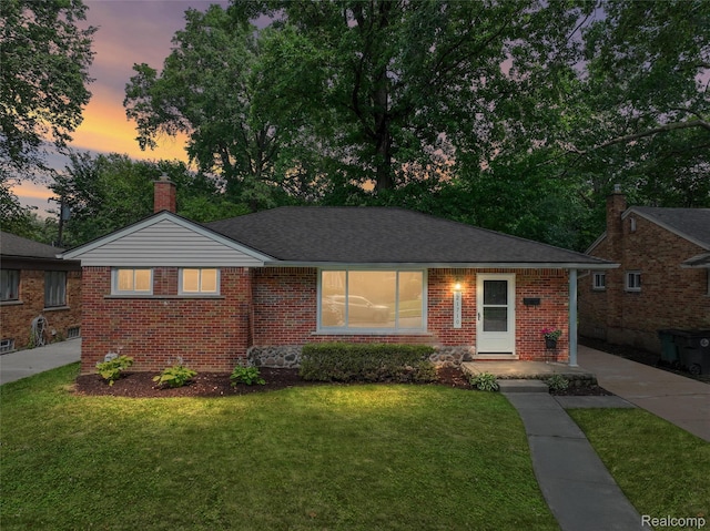 21710 Whitmore St, Oak Park, MI 48237 - view of front of home featuring brick siding, a front yard, and a chimney