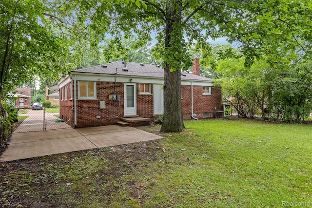 21710 Whitmore St, Oak Park, MI 48237 - back of house featuring brick siding, a gate, a chimney, and a patio area