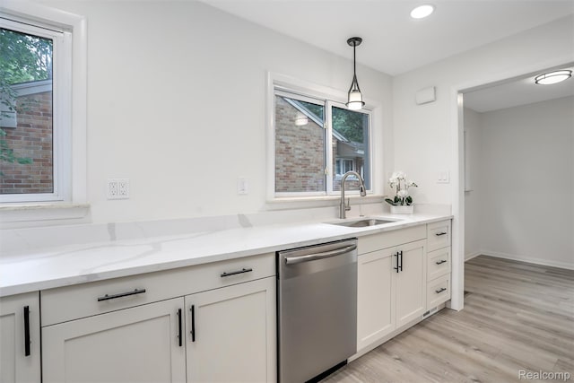 21710 Whitmore St, Oak Park, MI 48237 - kitchen featuring stainless steel dishwasher, light stone countertops, light wood finished floors, hanging light fixtures, and white cabinetry