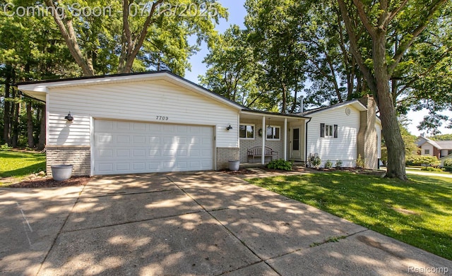 7709 Shelley Dr, Clarkston, MI 48348 - single story home with concrete driveway, a front yard, a garage, and brick siding