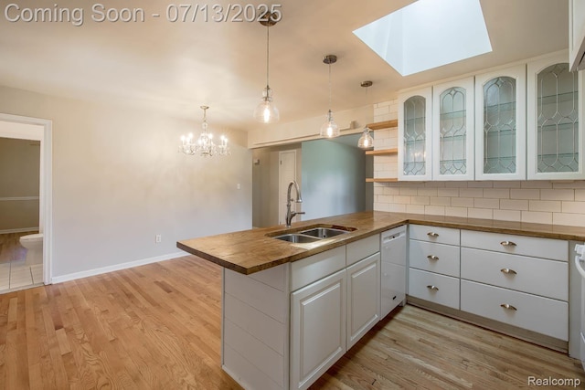 7709 Shelley Dr, Clarkston, MI 48348 - kitchen with wood counters, a peninsula, tasteful backsplash, and light wood-style floors