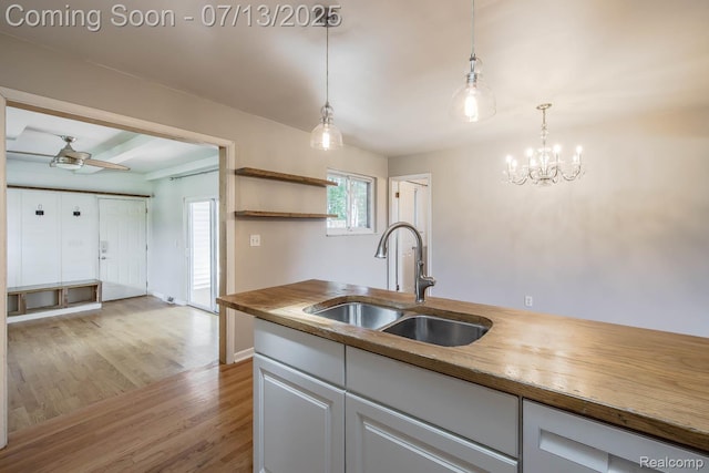 7709 Shelley Dr, Clarkston, MI 48348 - kitchen featuring light wood-style flooring, wooden counters, pendant lighting, a chandelier, and white cabinets