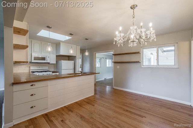 7709 Shelley Dr, Clarkston, MI 48348 - kitchen with white appliances, open shelves, a peninsula, backsplash, and light wood finished floors