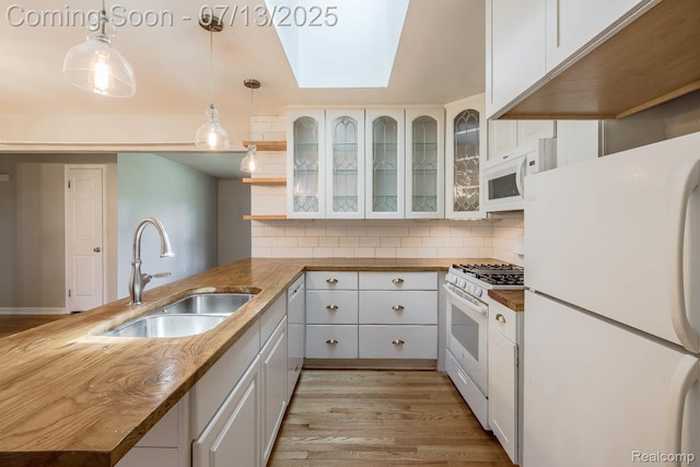 7709 Shelley Dr, Clarkston, MI 48348 - kitchen with white appliances, a skylight, a peninsula, and white cabinets