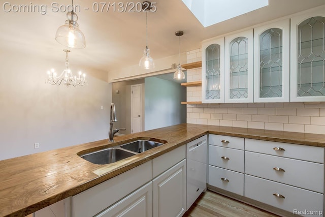 7709 Shelley Dr, Clarkston, MI 48348 - kitchen with wooden counters, dishwasher, decorative backsplash, white cabinets, and pendant lighting