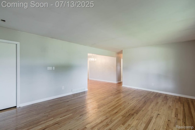 7709 Shelley Dr, Clarkston, MI 48348 - spare room with a chandelier and wood finished floors