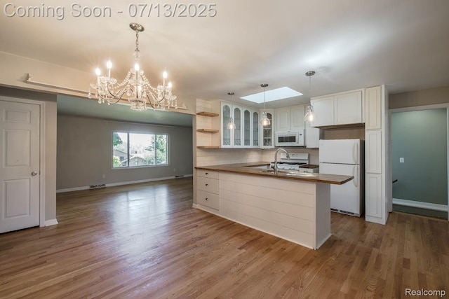 7709 Shelley Dr, Clarkston, MI 48348 - kitchen with white appliances, glass insert cabinets, backsplash, white cabinetry, and a chandelier
