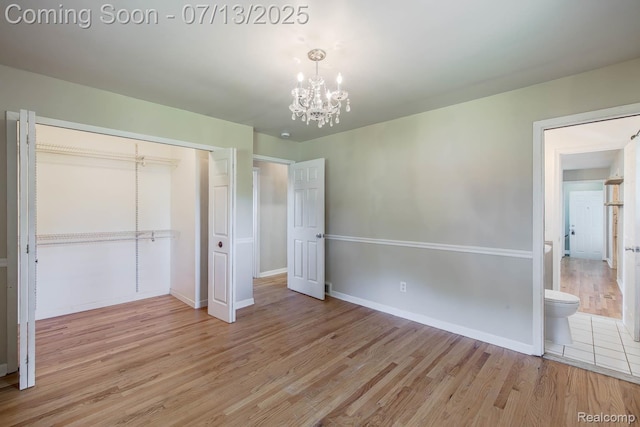 7709 Shelley Dr, Clarkston, MI 48348 - unfurnished bedroom with a chandelier, light wood-style flooring, and a closet