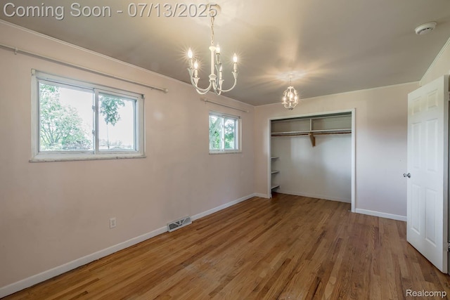 7709 Shelley Dr, Clarkston, MI 48348 - unfurnished bedroom with a chandelier, wood finished floors, and a closet