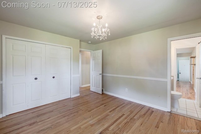 7709 Shelley Dr, Clarkston, MI 48348 - unfurnished bedroom with light wood-style flooring, a chandelier, and a closet