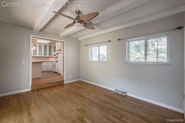 7709 Shelley Dr, Clarkston, MI 48348 - unfurnished bedroom featuring beamed ceiling, light wood-style flooring, and ceiling fan