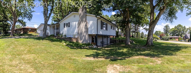 7709 Shelley Dr, Clarkston, MI 48348 - view of home's exterior with a chimney and a yard
