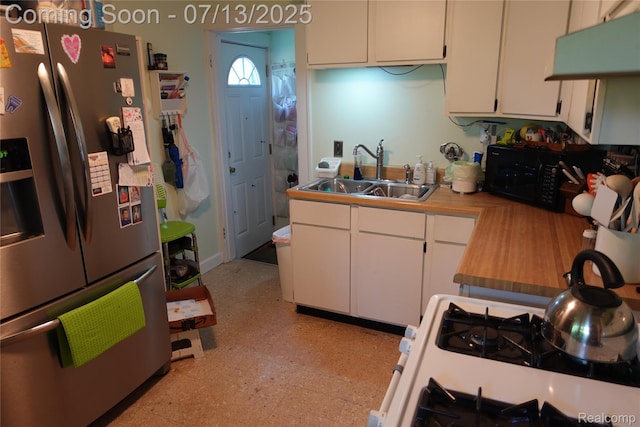 341 W Oakridge St W, Ferndale, MI 48220 - kitchen with stainless steel fridge, white cabinetry, range with gas cooktop, and black microwave