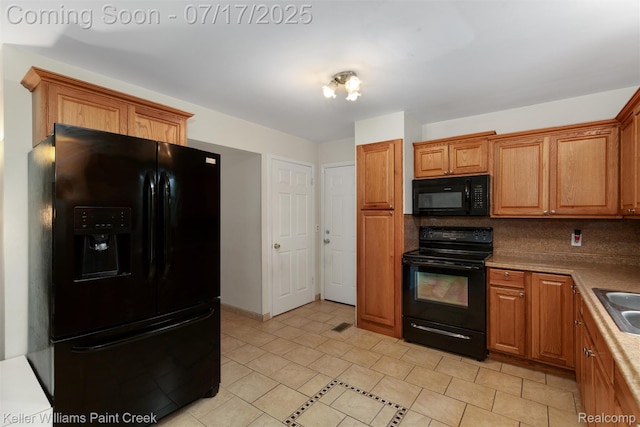 1046 Stonehenge Rd, Flint, MI 48532 - kitchen with black appliances, brown cabinets, and light tile patterned floors