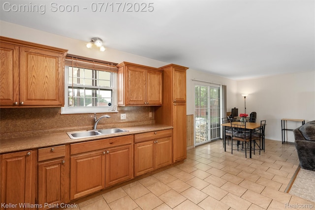 1046 Stonehenge Rd, Flint, MI 48532 - kitchen with tasteful backsplash, light countertops, a desk, and brown cabinets