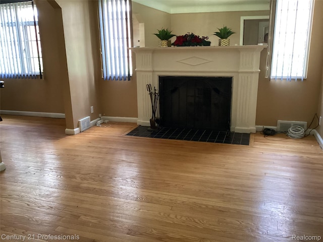 15451 Prest St, Detroit, MI 48227 - unfurnished living room with healthy amount of natural light, a tiled fireplace, and hardwood / wood-style floors