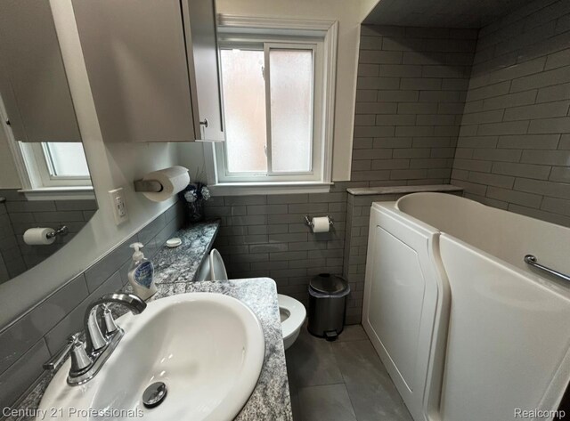 15451 Prest St, Detroit, MI 48227 - bathroom featuring tile walls, a garden tub, and tile patterned flooring