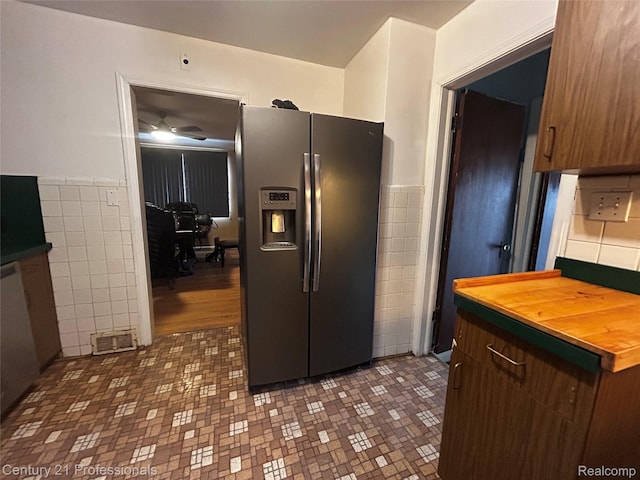 15451 Prest St, Detroit, MI 48227 - kitchen with stainless steel fridge with ice dispenser, tile walls, ceiling fan, wainscoting, and butcher block countertops