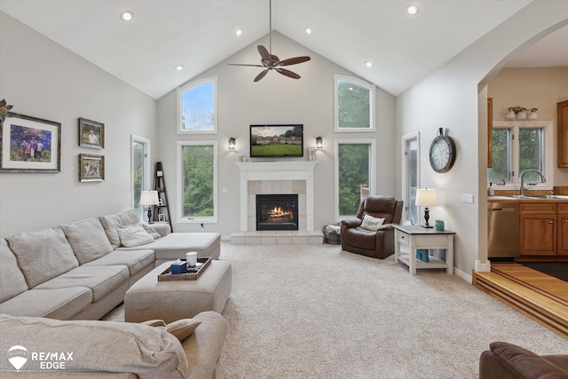 7266 Dodge Rd, Montrose, MI 48457 - living area featuring high vaulted ceiling, ceiling fan, arched walkways, a tile fireplace, and recessed lighting