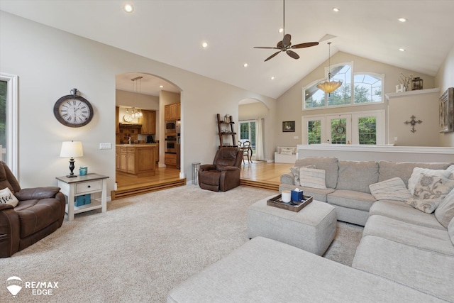 7266 Dodge Rd, Montrose, MI 48457 - living area featuring arched walkways, healthy amount of natural light, light colored carpet, ceiling fan, and high vaulted ceiling