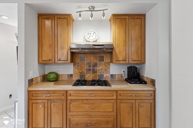 7266 Dodge Rd, Montrose, MI 48457 - kitchen featuring gas stovetop, brown cabinets, tasteful backsplash, and light countertops