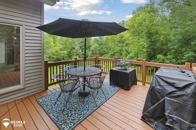 7266 Dodge Rd, Montrose, MI 48457 - deck with outdoor dining area, a grill, and a forest view