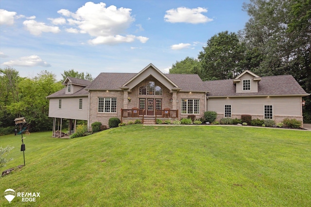 7266 Dodge Rd, Montrose, MI 48457 - view of front facade with a wooden deck, brick siding, a front lawn, and roof with shingles