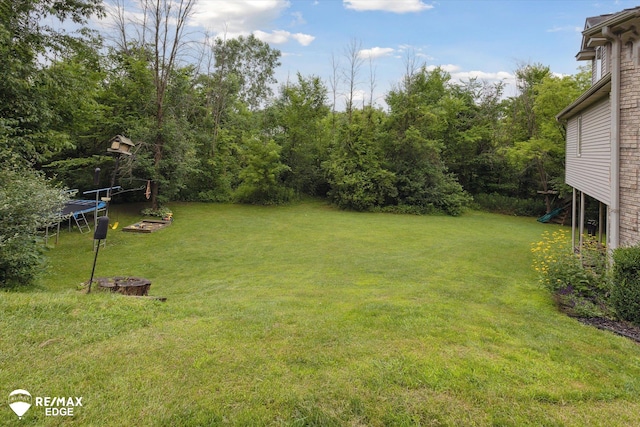 7266 Dodge Rd, Montrose, MI 48457 - view of grassy yard featuring a trampoline