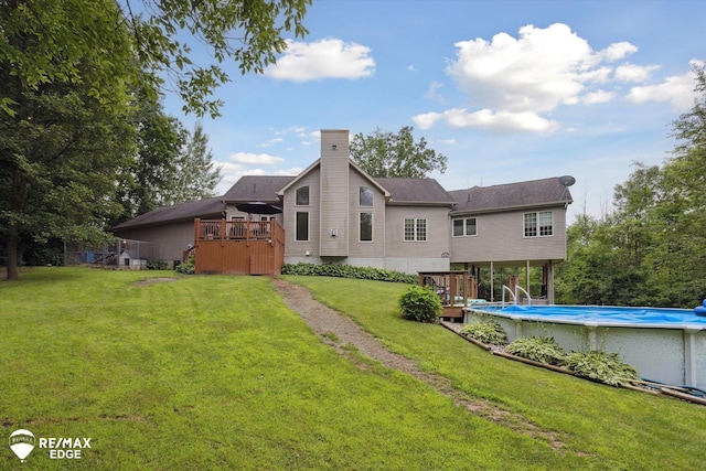 7266 Dodge Rd, Montrose, MI 48457 - back of house with a wooden deck, an outdoor pool, a lawn, and a chimney