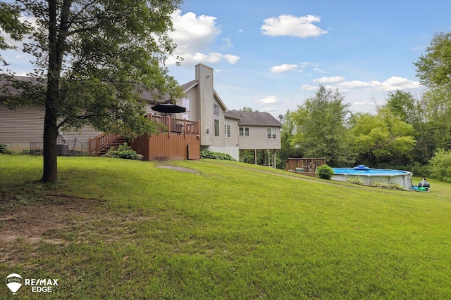 7266 Dodge Rd, Montrose, MI 48457 - view of grassy yard featuring stairs, a wooden deck, and an outdoor pool