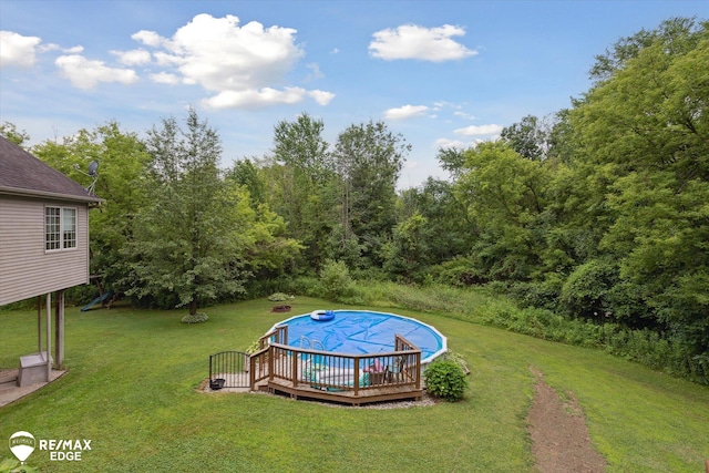 7266 Dodge Rd, Montrose, MI 48457 - view of grassy yard with a covered pool and a deck