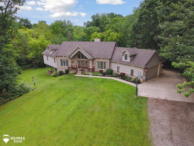 7266 Dodge Rd, Montrose, MI 48457 - view of front facade with concrete driveway, a front lawn, a chimney, a wooded view, and a shingled roof