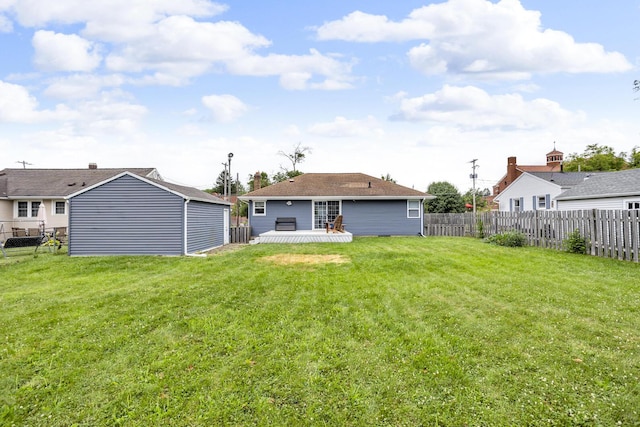 723 S Bowen St, Jackson, MI 49203 - rear view of property featuring a fenced backyard, a wooden deck, and an outbuilding