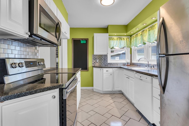 723 S Bowen St, Jackson, MI 49203 - kitchen with stainless steel appliances, white cabinetry, tasteful backsplash, and light tile patterned flooring