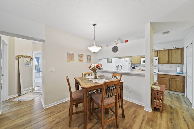 824 W Barrington Cir, Jackson, MI 49203 - dining area with light wood-style floors and a textured ceiling