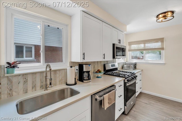 23139 Deziel St, Saint Clair Shores, MI 48082 - kitchen with appliances with stainless steel finishes, backsplash, white cabinetry, light countertops, and light wood-type flooring
