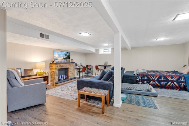 23139 Deziel St, Saint Clair Shores, MI 48082 - living room featuring wood finished floors, a textured ceiling, and a stone fireplace