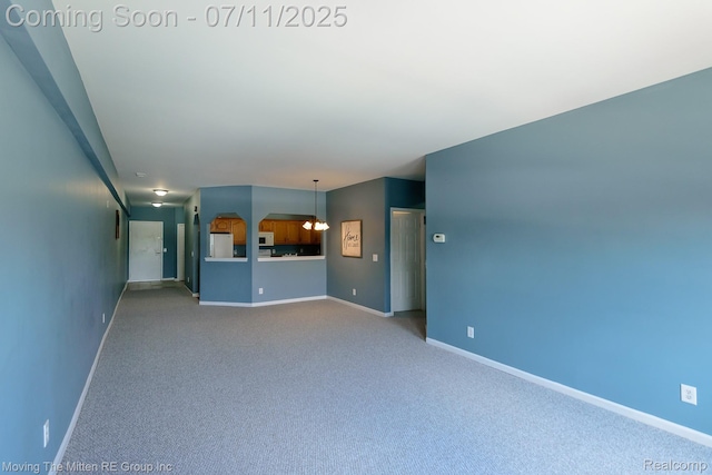 231 Main St, Belleville, MI 48111 - unfurnished living room with carpet flooring and a chandelier