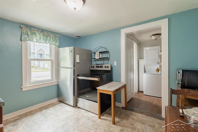 1312 Bayliss St, Midland, MI 48640 - kitchen with appliances with stainless steel finishes and stacked washer / drying machine