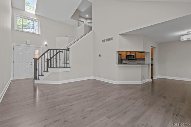4350 Pine Ridge Ct, Ann Arbor, MI 48105 - unfurnished living room featuring a high ceiling, stairway, and wood finished floors