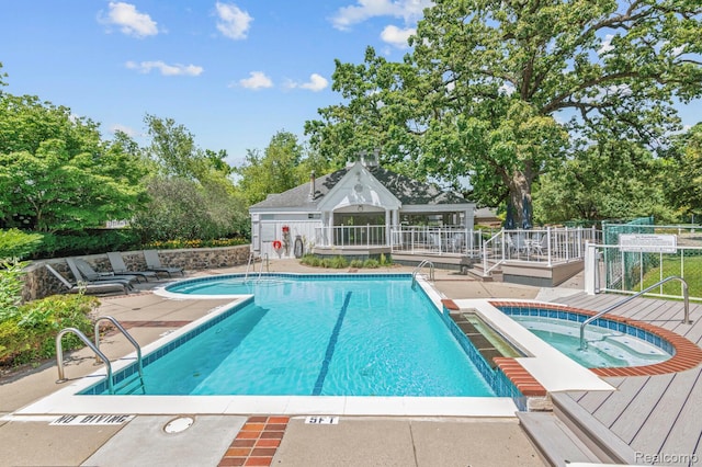 4350 Pine Ridge Ct, Ann Arbor, MI 48105 - community pool featuring a hot tub, a wooden deck, a patio area, and view of wooded area