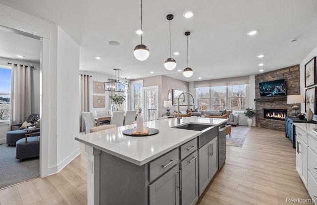 49976 Kent Ct, Canton, MI 48188 - kitchen with gray cabinets, open floor plan, a stone fireplace, light countertops, and recessed lighting