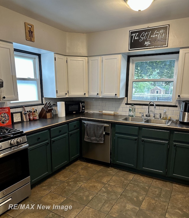 419 N Birney St, Bay City, MI 48708 - kitchen featuring appliances with stainless steel finishes, white cabinets, plenty of natural light, and backsplash
