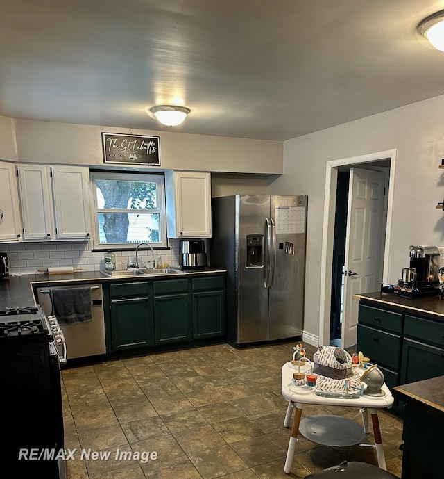 419 N Birney St, Bay City, MI 48708 - kitchen featuring stainless steel appliances, dark countertops, decorative backsplash, white cabinets, and green cabinetry