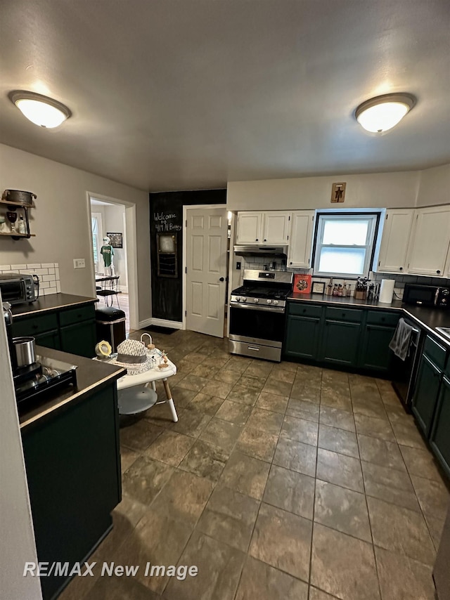 419 N Birney St, Bay City, MI 48708 - kitchen with stainless steel range with gas cooktop, white cabinets, dark countertops, and tasteful backsplash
