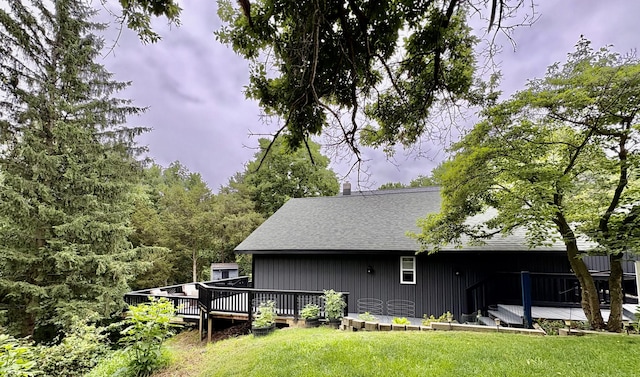 12141 Lawrence Rd, Brooklyn, MI 49230 - back of house with a wooden deck, a lawn, roof with shingles, a chimney, and board and batten siding