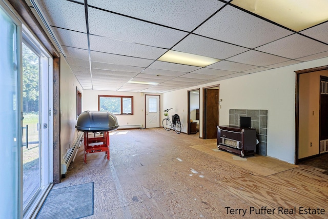 2860 Fenner Rd, Muskegon, MI 49445 - interior space with a wood stove, a baseboard radiator, plenty of natural light, and a paneled ceiling