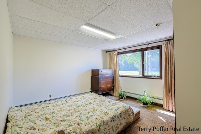 2860 Fenner Rd, Muskegon, MI 49445 - bedroom featuring wood finished floors, a paneled ceiling, and a baseboard radiator