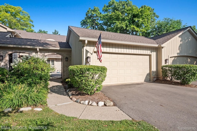 1125 Meadowglen Ct, Bloomfield Hills, MI 48304 - view of front facade with a garage, driveway, brick siding, and board and batten siding
